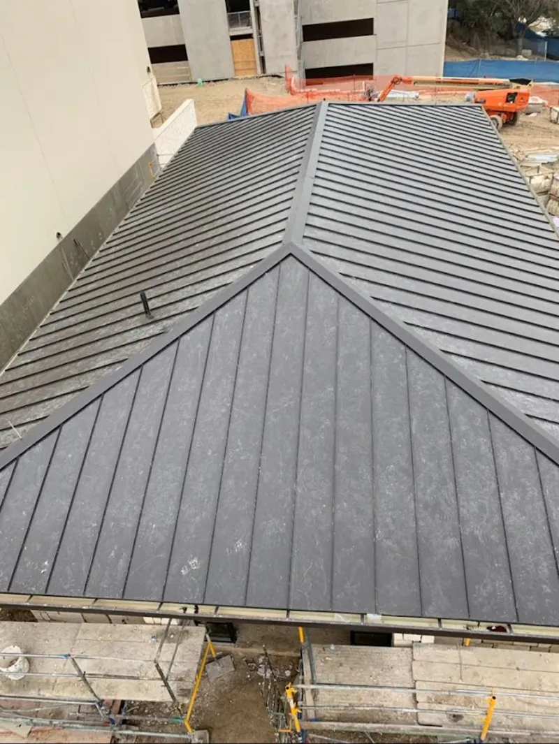 Commercial metal roof construction with crane equipment in Stockton